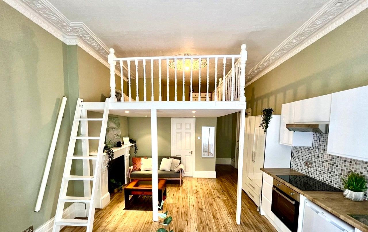 Charming Notting Hill studio with ornate ceiling, mock fireplace and mezzanine bedroom rents for £1,520 a month but comes with limited headroom and quirky layout.