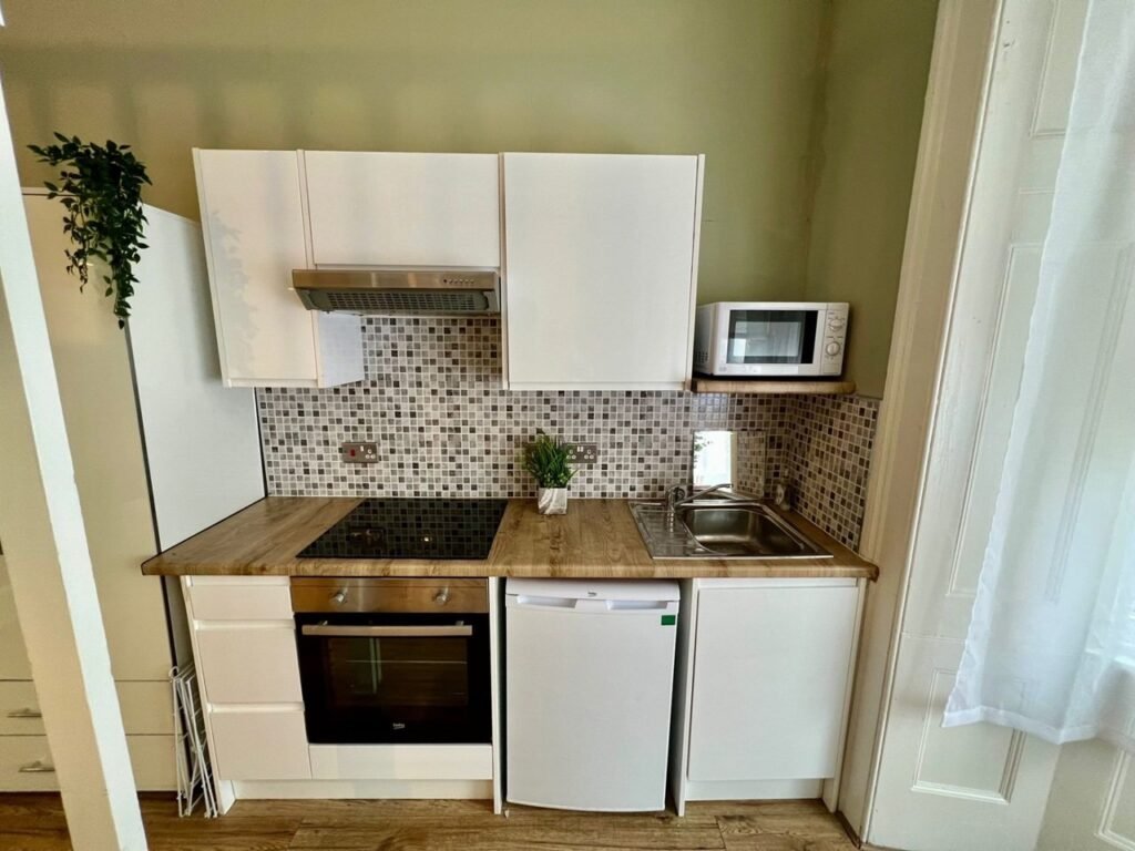 Charming Notting Hill studio with ornate ceiling, mock fireplace and mezzanine bedroom rents for £1,520 a month but comes with limited headroom and quirky layout.