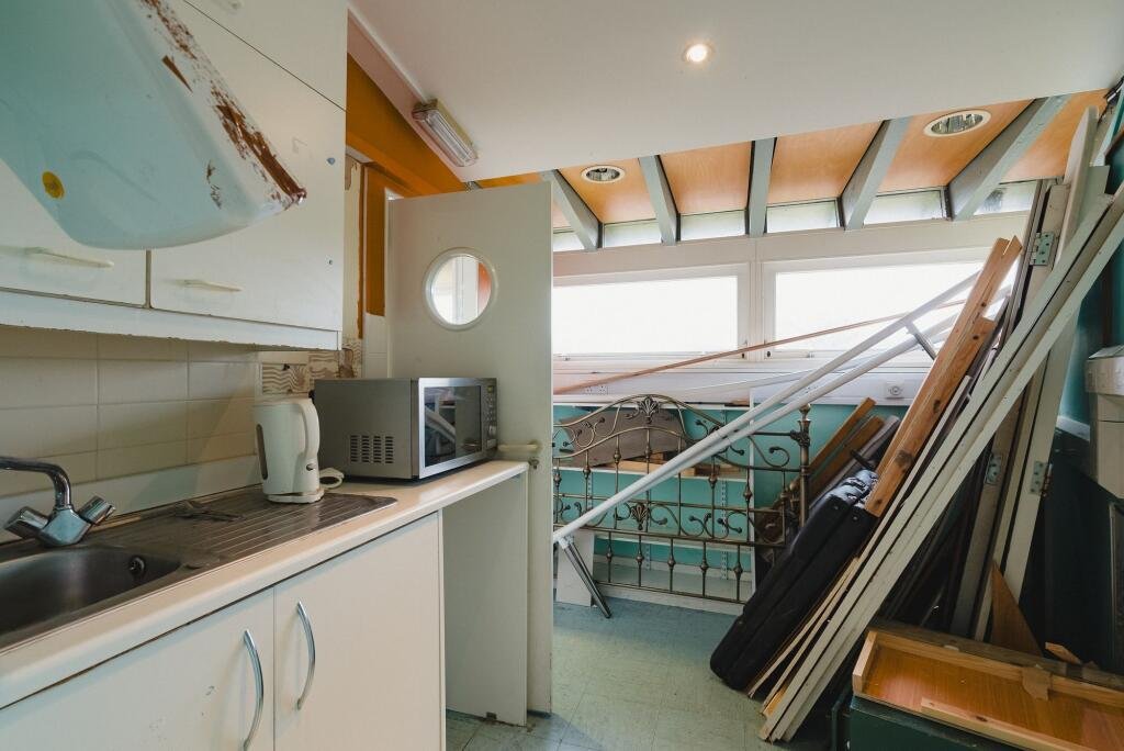 A quirky Hobbit style home in Crediton built into a hillside is on sale for £235,000 offering a unique design, planning permission and a rare development opportunity.