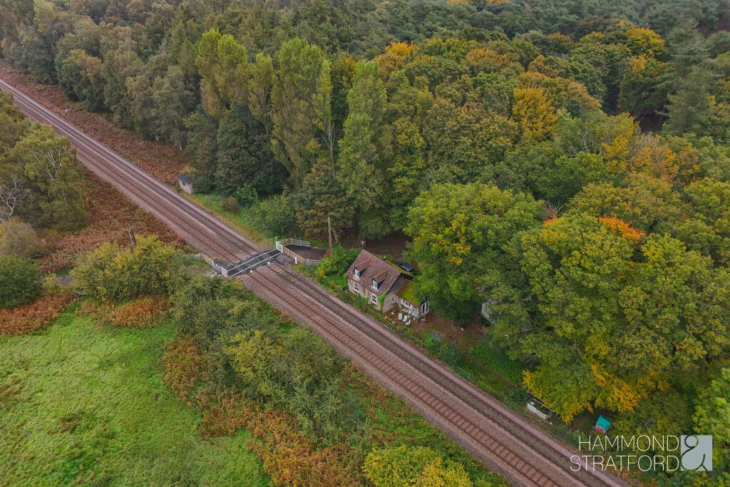 A £300,000 two-bedroom cottage in Norfolk offers rustic charm and woodland seclusion just feet from train tracks, blending period character with unique rural living.
