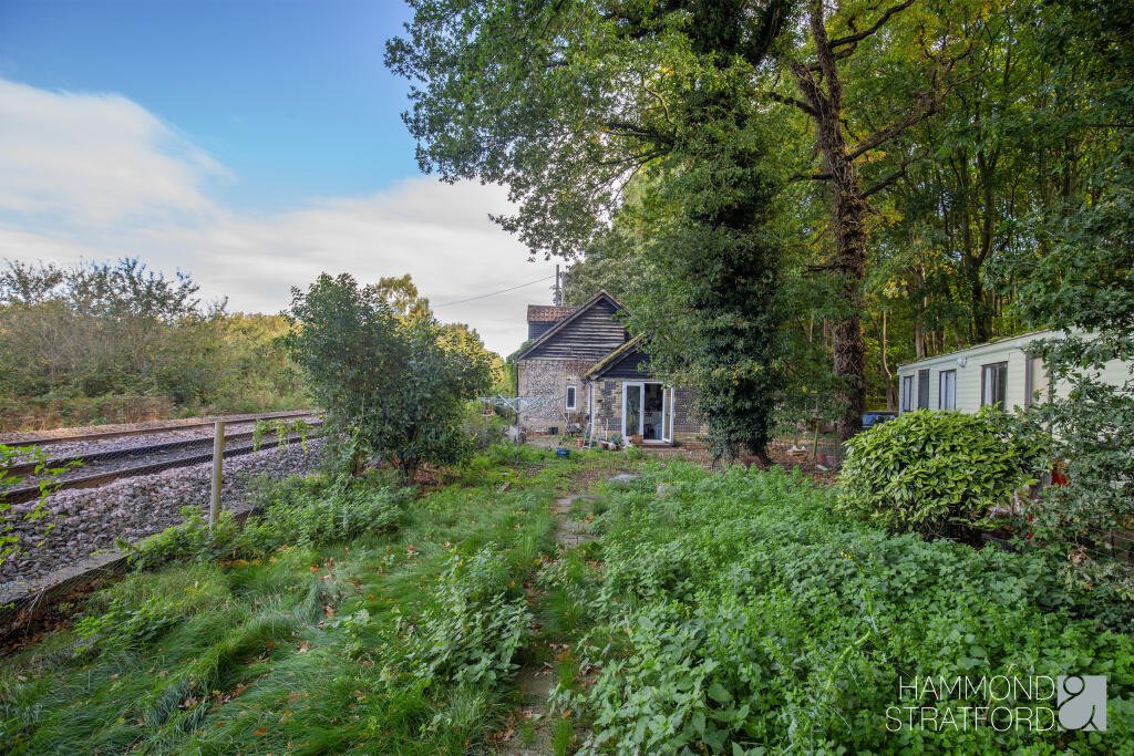 A £300,000 two-bedroom cottage in Norfolk offers rustic charm and woodland seclusion just feet from train tracks, blending period character with unique rural living.