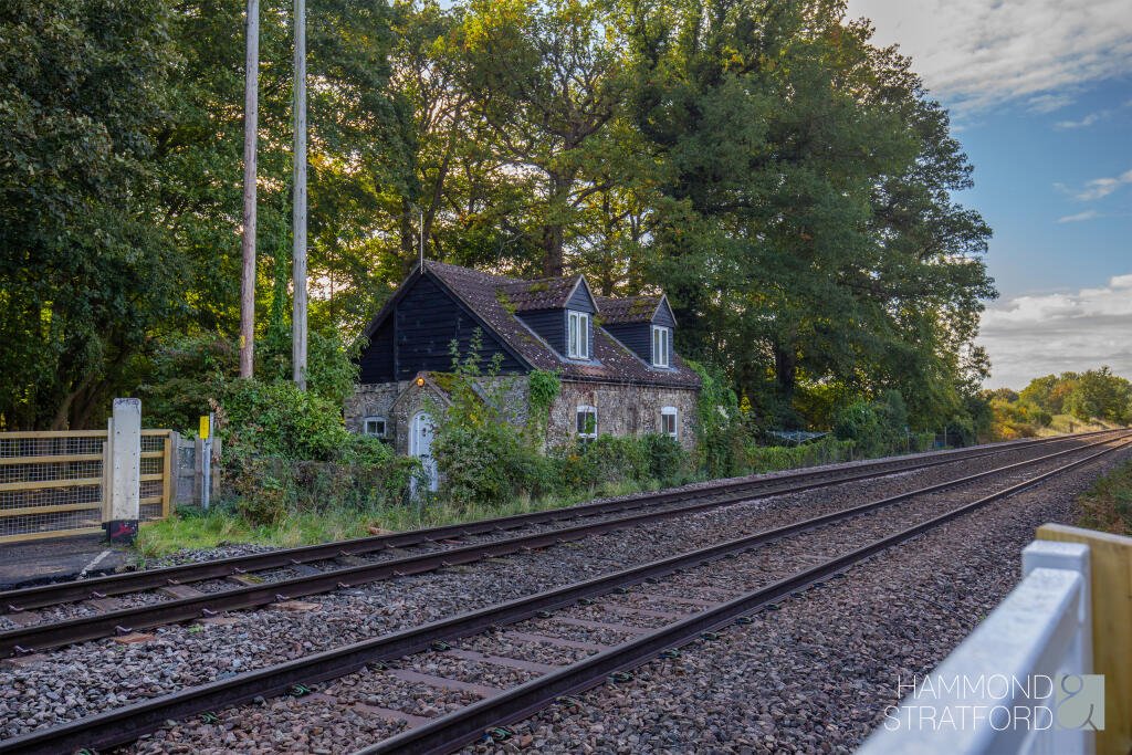 A £300,000 two-bedroom cottage in Norfolk offers rustic charm and woodland seclusion just feet from train tracks, blending period character with unique rural living.