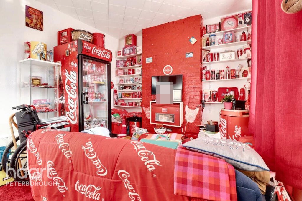 Unassuming three-bed home in Peterborough listed at £240,000 hides a striking Coca Cola themed lounge with bold red walls, memorabilia, and unique retro inspired decor.