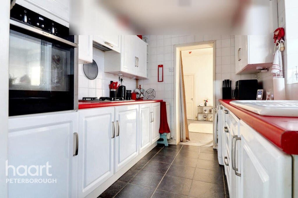 Unassuming three-bed home in Peterborough listed at £240,000 hides a striking Coca Cola themed lounge with bold red walls, memorabilia, and unique retro inspired decor.