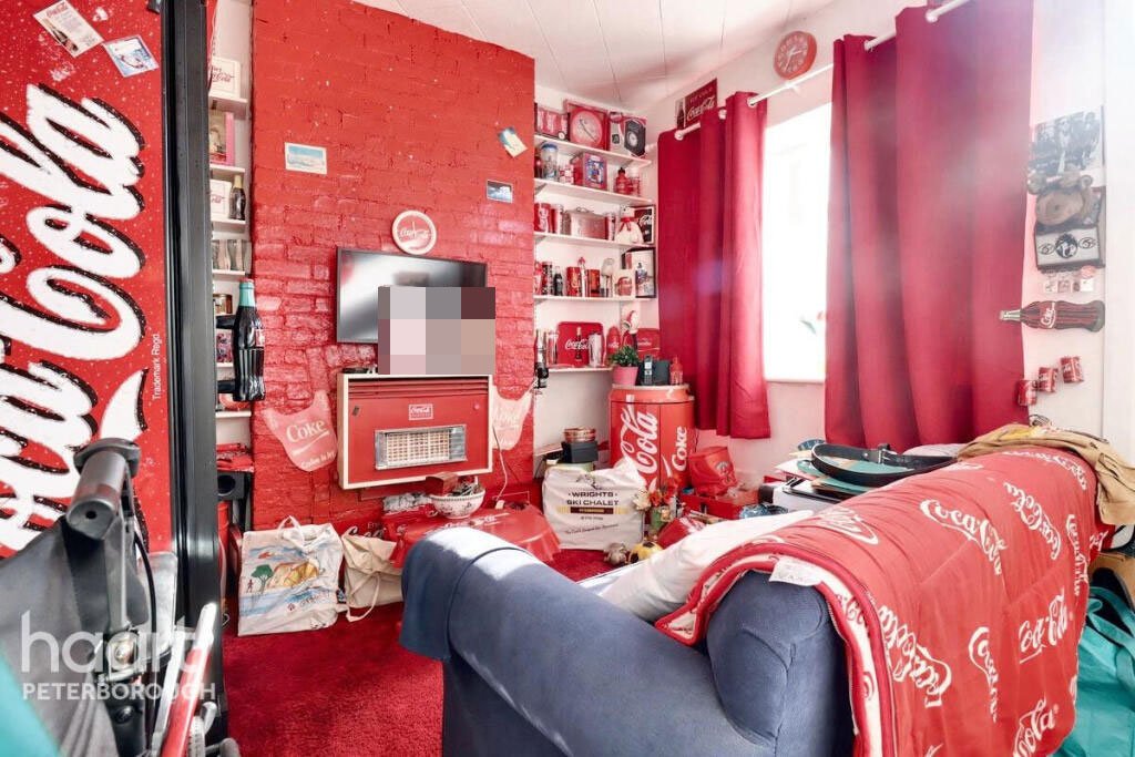 Unassuming three-bed home in Peterborough listed at £240,000 hides a striking Coca Cola themed lounge with bold red walls, memorabilia, and unique retro inspired decor.
