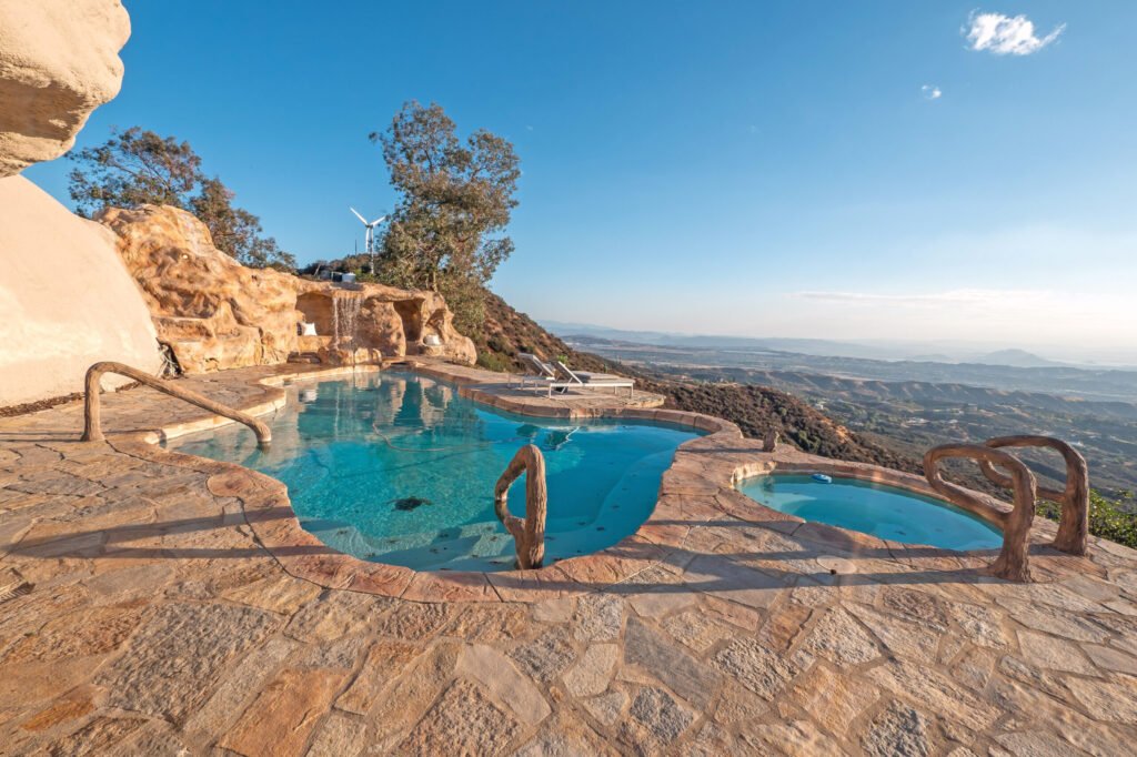 A $3 million California mountain home resembling The Flintstones’ Bedrock is up for sale, featuring domed architecture, a rock-carved pool, and breathtaking panoramic views.