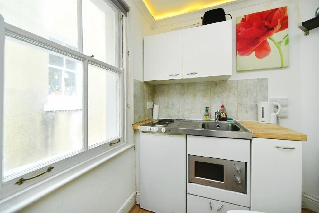 A Brighton studio flat so small you can cook from bed is on sale for £110,000, offering a compact seafront retreat with a kitchen, shower room and shared freehold.