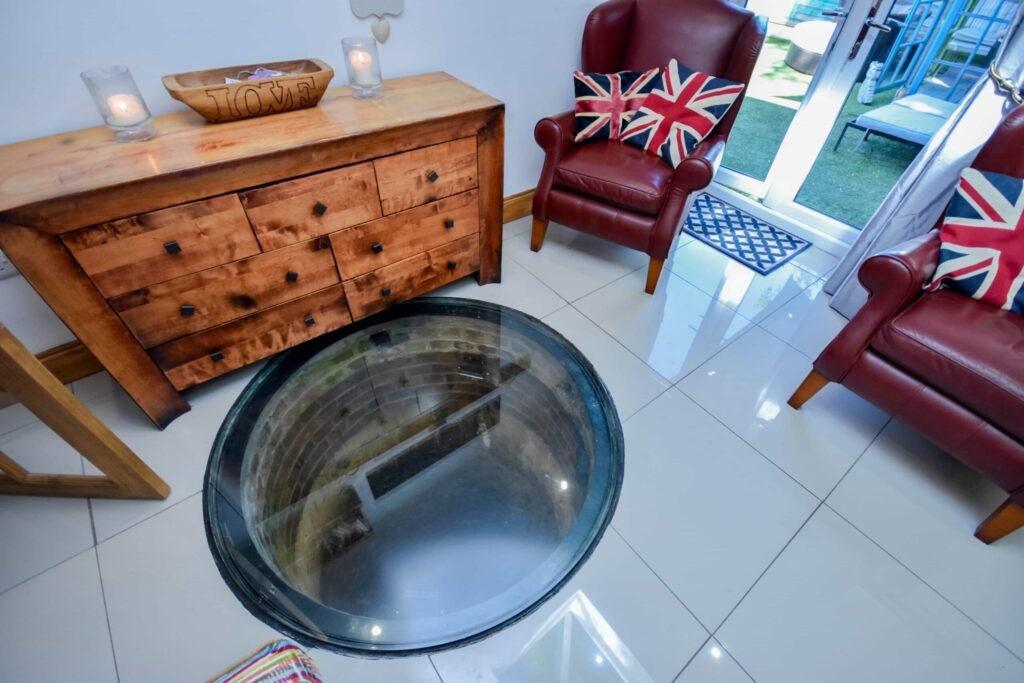 A quirky 1824 cottage in Penkhull priced at 410000 pounds features exposed beams modern spaces and a restored glass covered water well offering rare historic charm today.