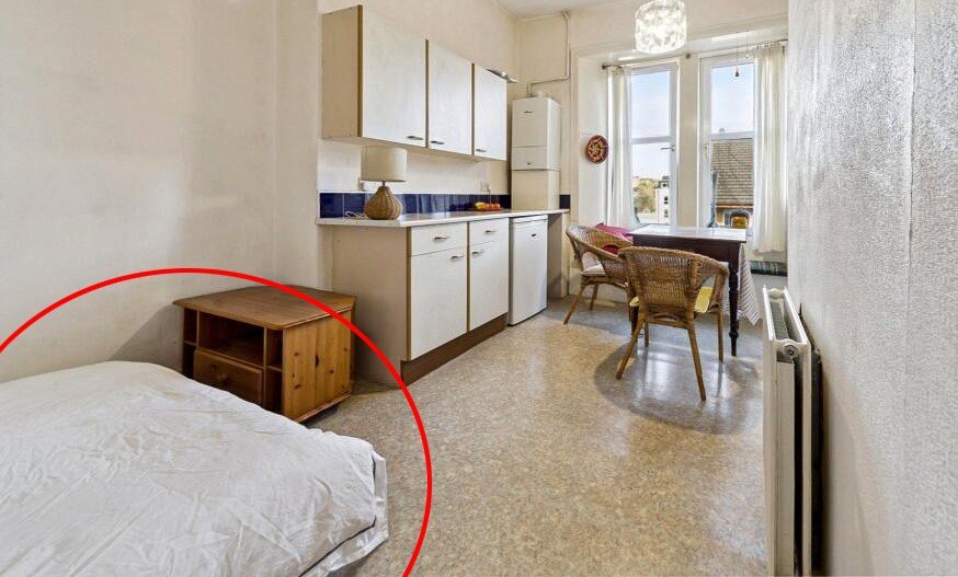 A £99,000 Glasgow flat has hit the market with an unusual twist — the double bed is inside the kitchen, opposite the oven and washing machine, creating a truly quirky layout.