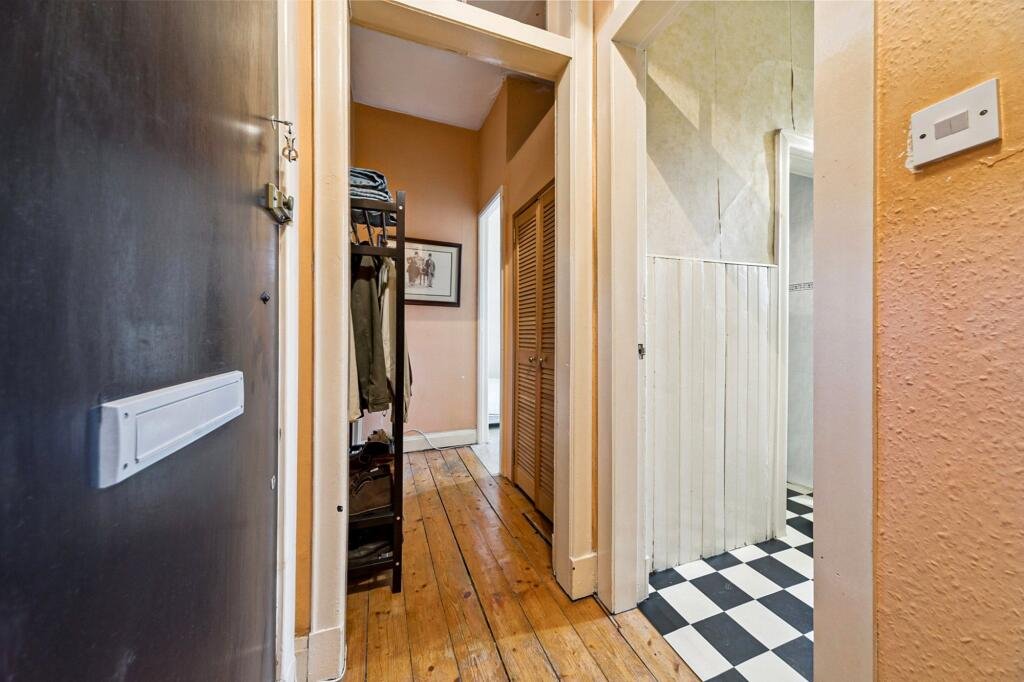 A £99,000 Glasgow flat has hit the market with an unusual twist — the double bed is inside the kitchen, opposite the oven and washing machine, creating a truly quirky layout.