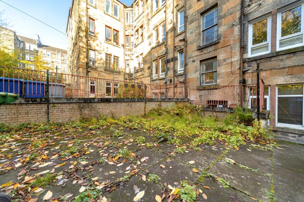 A £99,000 Glasgow flat has hit the market with an unusual twist — the double bed is inside the kitchen, opposite the oven and washing machine, creating a truly quirky layout.