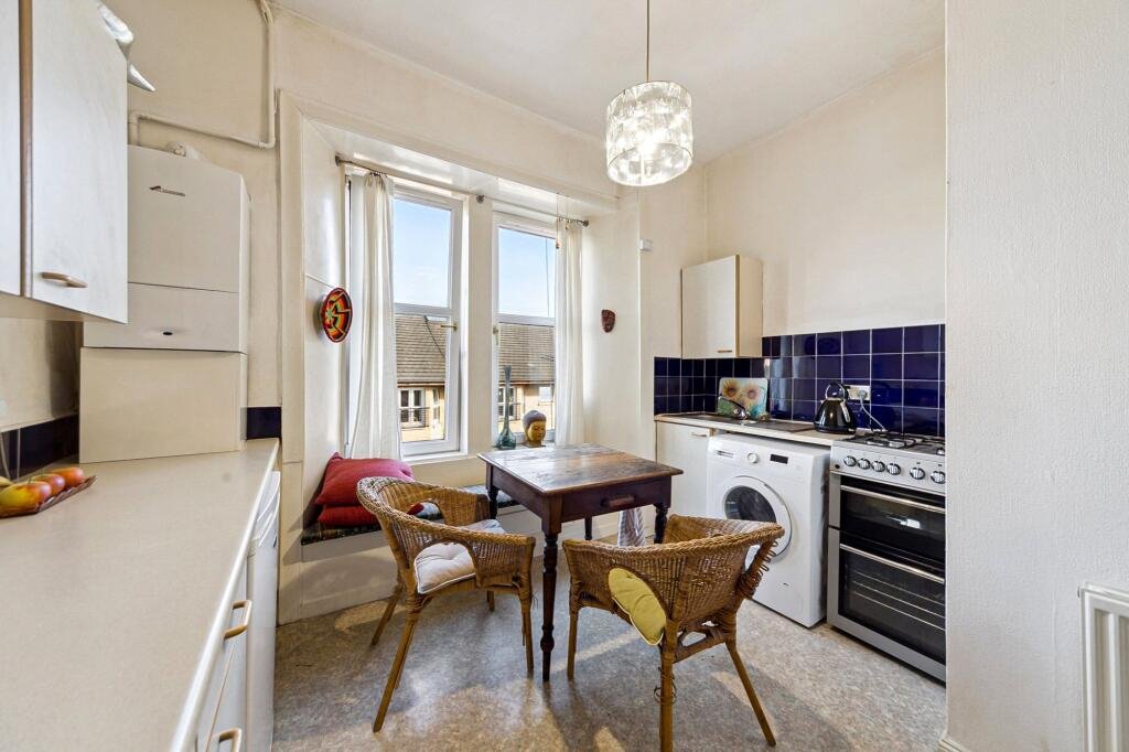 A £99,000 Glasgow flat has hit the market with an unusual twist — the double bed is inside the kitchen, opposite the oven and washing machine, creating a truly quirky layout.
