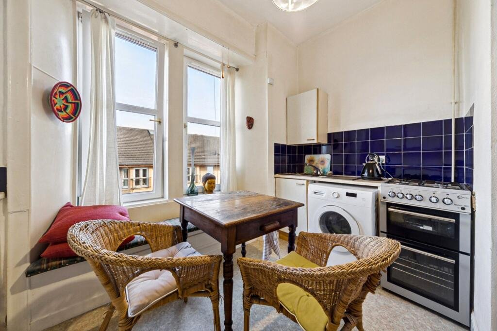 A £99,000 Glasgow flat has hit the market with an unusual twist — the double bed is inside the kitchen, opposite the oven and washing machine, creating a truly quirky layout.