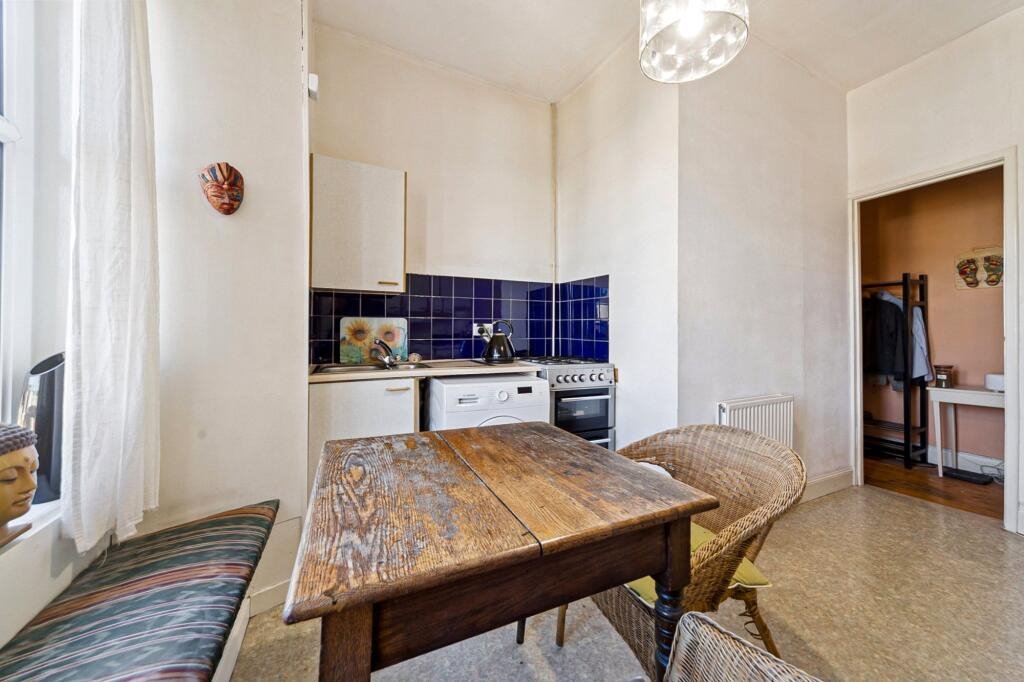 A £99,000 Glasgow flat has hit the market with an unusual twist — the double bed is inside the kitchen, opposite the oven and washing machine, creating a truly quirky layout.