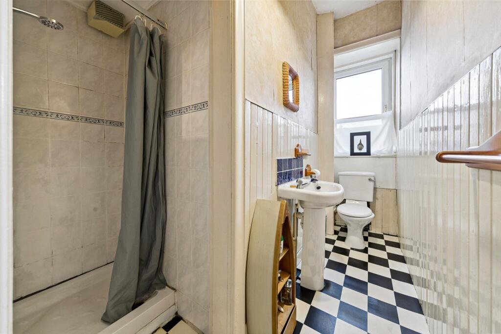 A £99,000 Glasgow flat has hit the market with an unusual twist — the double bed is inside the kitchen, opposite the oven and washing machine, creating a truly quirky layout.