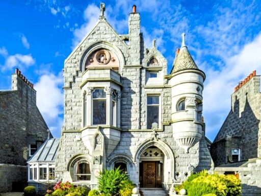 A stunning £1.5m pink granite storybook castle in Aberdeen hits the market offering eight bedrooms grand period details stained glass turrets and lavish interiors in a restored A listed home.