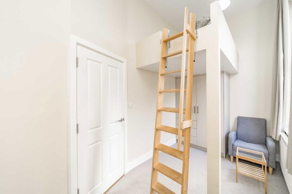 A £450000 London flat sparks attention with steep ladder style beds raised above furniture-offering a quirky space saving layout in a modern Finsbury Park apartment.