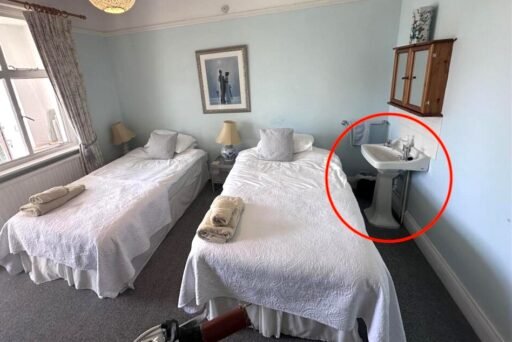 A £1,200-a-month seaside flat with a sink beside the bed has gone viral, leaving renters baffled by the quirky layout, high deposit, and income requirements.