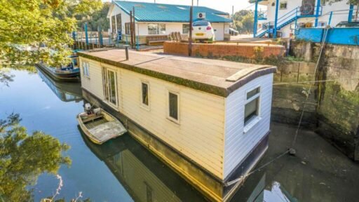 Quirky floating caravan turned houseboat hits the Thames market for £99,950, offering one bedroom, log burner, roof seating and full-time riverside living