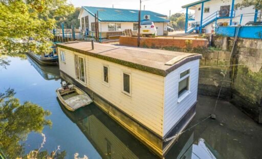 Quirky floating caravan turned houseboat hits the Thames market for £99,950, offering one bedroom, log burner, roof seating and full-time riverside living