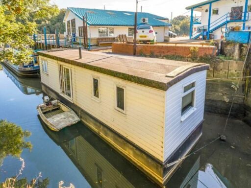 Quirky floating caravan turned houseboat hits the Thames market for £99,950, offering one bedroom, log burner, roof seating and full-time riverside living