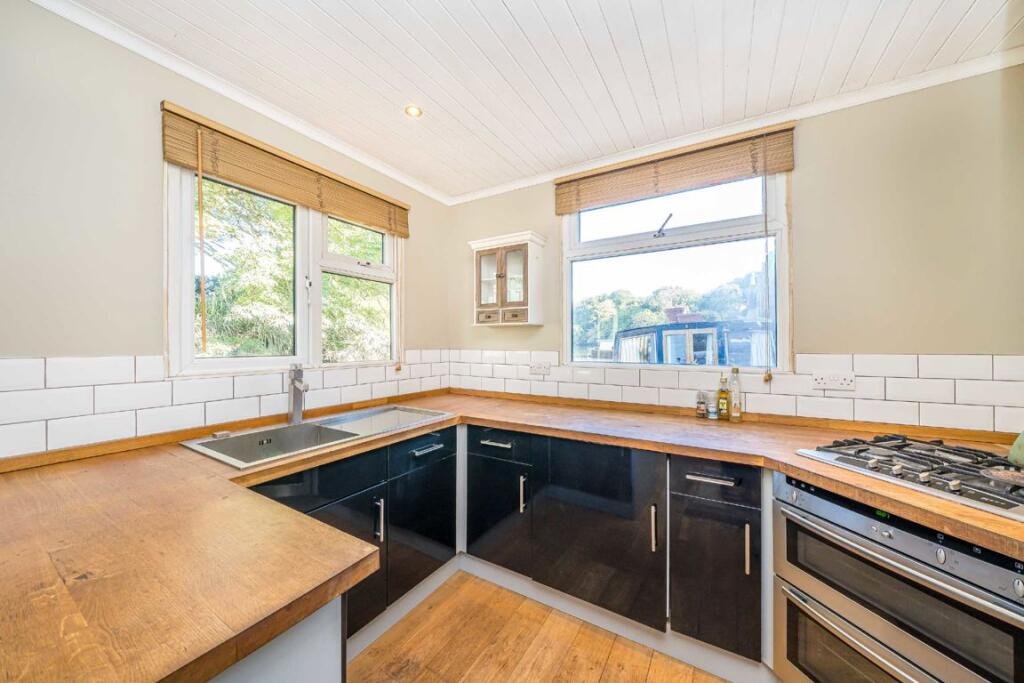 Quirky floating caravan turned houseboat hits the Thames market for £99,950, offering one bedroom, log burner, roof seating and full-time riverside living