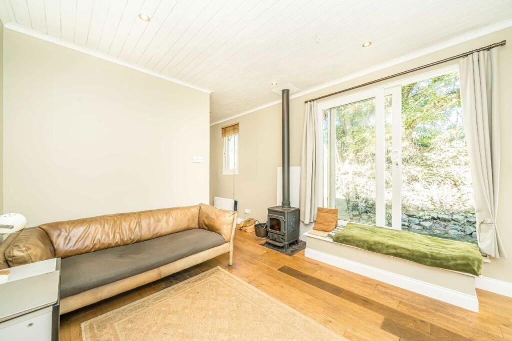 Quirky floating caravan turned houseboat hits the Thames market for £99,950, offering one bedroom, log burner, roof seating and full-time riverside living