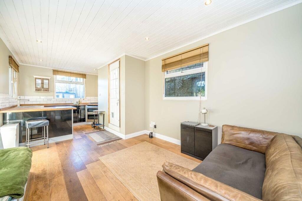 Quirky floating caravan turned houseboat hits the Thames market for £99,950, offering one bedroom, log burner, roof seating and full-time riverside living