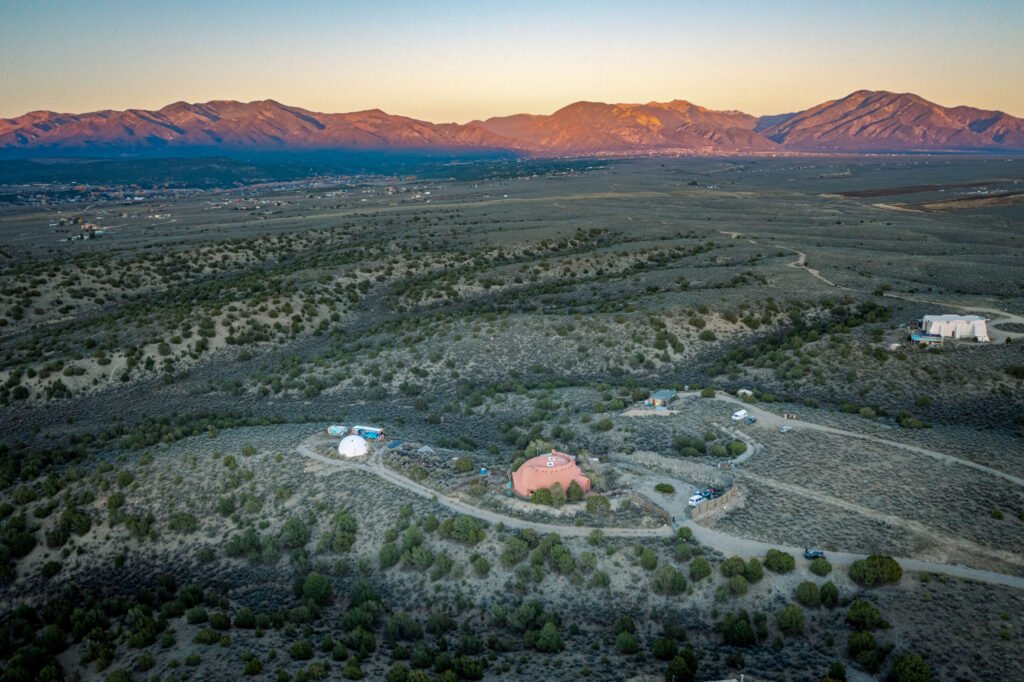 A whimsical pink dome home inspired by rainforests and desert landscapes has gone on sale for £1.2m, offering eco luxury, yoga domes and magical interiors in New Mexico