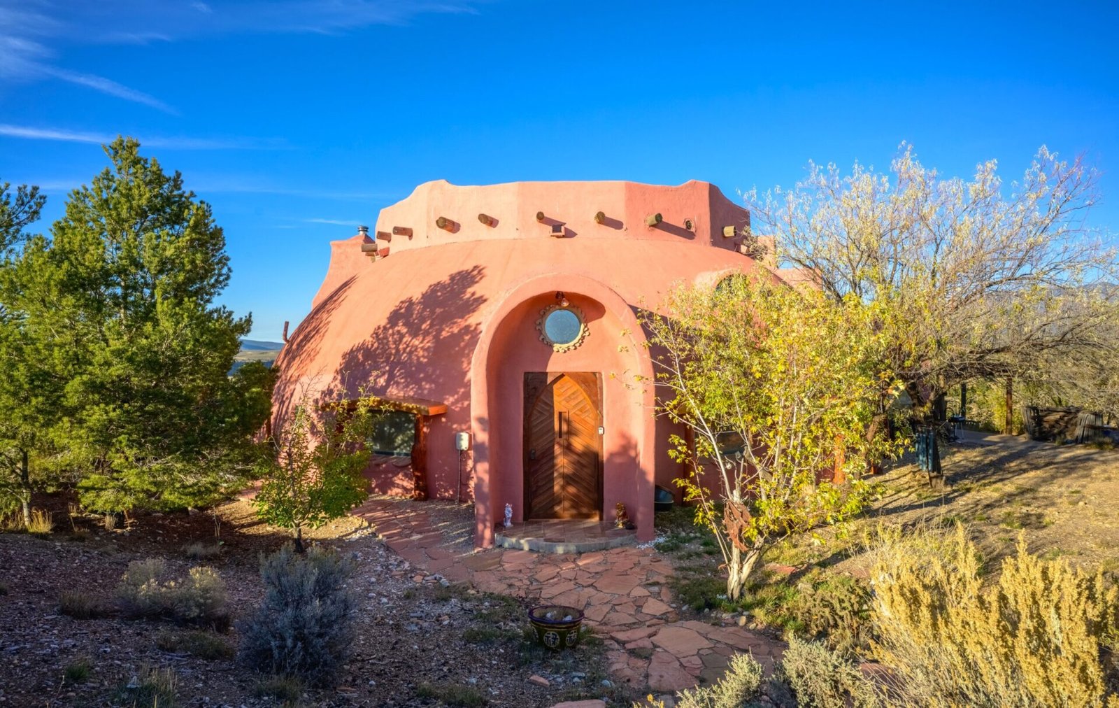 A whimsical pink dome home inspired by rainforests and desert landscapes has gone on sale for £1.2m, offering eco luxury, yoga domes and magical interiors in New Mexico