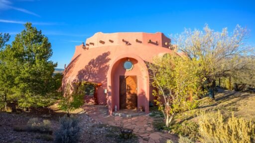 A whimsical pink dome home inspired by rainforests and desert landscapes has gone on sale for £1.2m, offering eco luxury, yoga domes and magical interiors in New Mexico