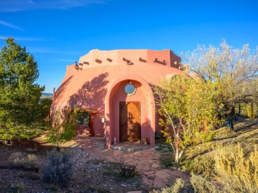 A whimsical pink dome home inspired by rainforests and desert landscapes has gone on sale for £1.2m, offering eco luxury, yoga domes and magical interiors in New Mexico