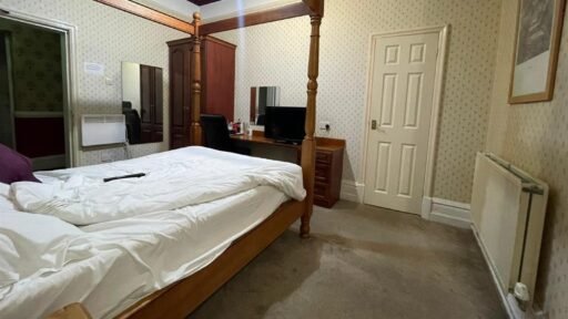 A dilapidated hotel bedroom with stained carpets and peeling wallpaper in Preston is on sale for £40,000, leaving bewildered Brits questioning what exactly they would be buying.