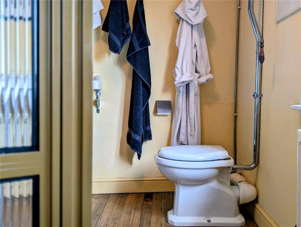 A quaint £220,000 cottage has gone on the market - but its bathroom arrangement, with the loo and bath behind see-through glass, may leave buyers feeling flushed.